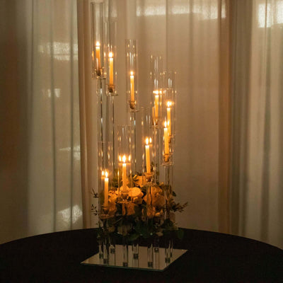 Elegant floral candle centerpiece with glass tubes and warm lighting.
