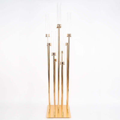 Gold floor lamp with five glass tubes on a white background.