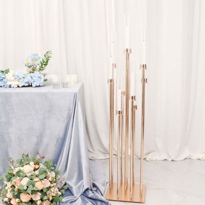 Elegant rose gold candle holder with clear glass tubes in a styled setting.