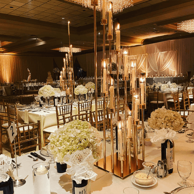 Elegant table setting with tall candle holders and floral centerpieces at a wedding reception.