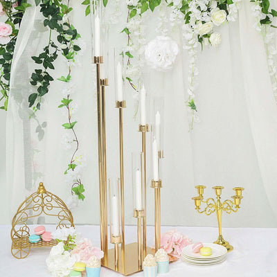 Elegant gold candle holder centerpiece with glass tubes and candles, perfect for events.