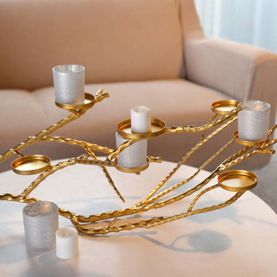 Gold candle holder centerpiece with glass votives on a table.