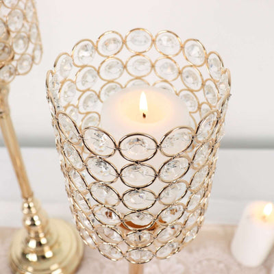 Elegant gold candle holder with crystal accents and lit candle.