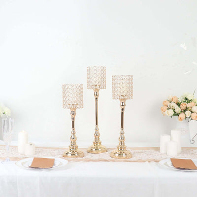 Elegant gold candle holders with decorative shades for table decor.