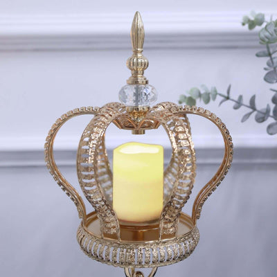Gold crown candle holder with decorative crystals and a soft yellow candle inside.