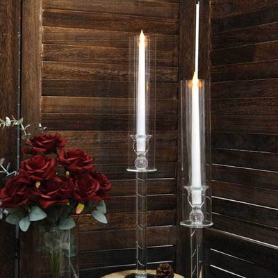 Elegant glass candle holders with white candles and red roses.