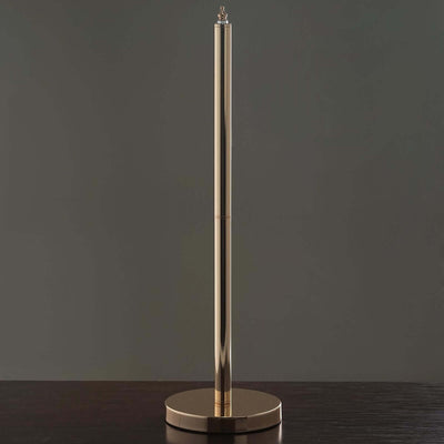 Gold paper towel holder on a dark wooden surface.