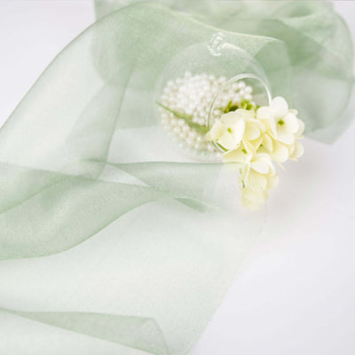 Light green sheer fabric with delicate flowers and pearls, elegantly draped.