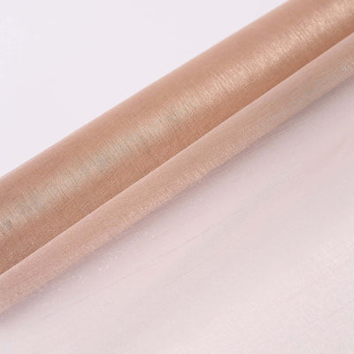 Shiny rose gold and soft pink fabric rolls on a plain background.