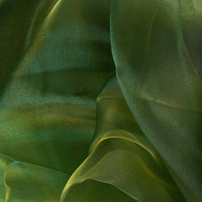 Green sheer fabric draping with soft, flowing texture and gradient tones.