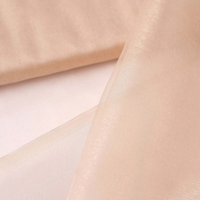 Sheer beige fabric draped elegantly on a smooth surface.