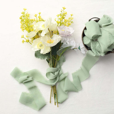 Floral bouquet with yellow and white flowers and green ribbon on a light background.