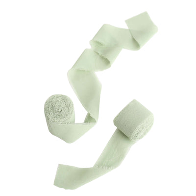 Green fabric ribbon rolls on a white background.