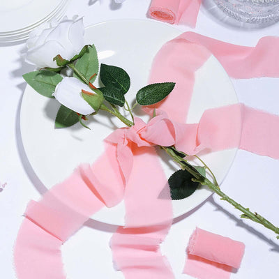 White rose with pink ribbon on a plate, styled for a decorative table setting.