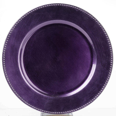 Purple decorative plate with beaded rim on a plain backdrop