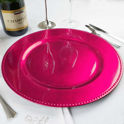 Glossy pink charger plate on a dining table setting.