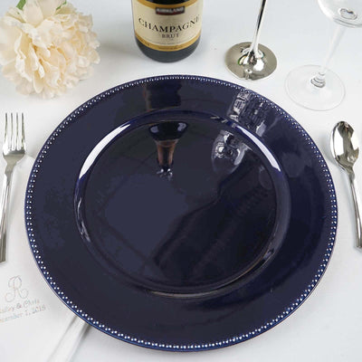 Navy blue dinner plate with beaded rim on a table setting.