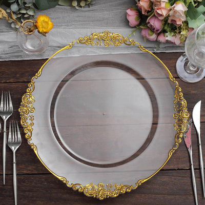Elegant clear plate with gold ornate trim on a rustic wooden table.