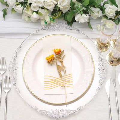 Elegant dinner table setting with floral accents and ornate dinnerware.
