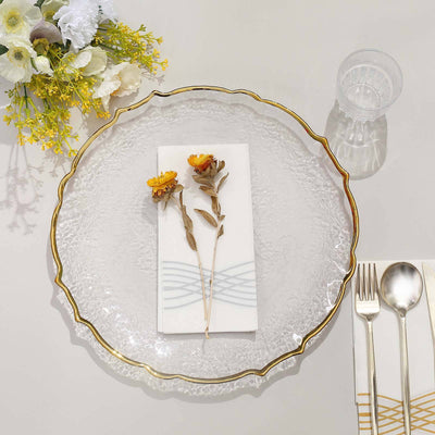 Elegant glass plate with gold rim, floral decor, and napkin setup.