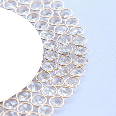 Elegant round mirror with crystal accents on a soft blue background.