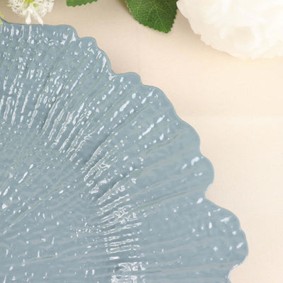 Blue decorative plate with a scalloped edge on a soft background.
