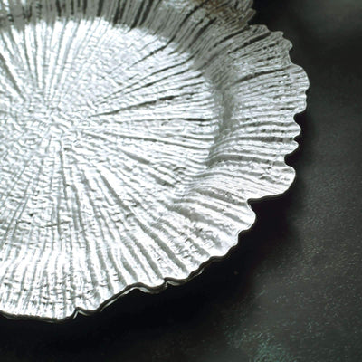 Silver decorative plate with textured design and scalloped edge.