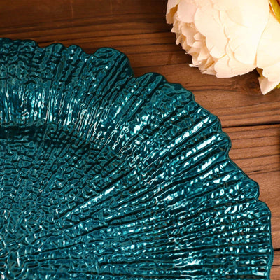 Teal decorative plate with textured surface on wooden background.