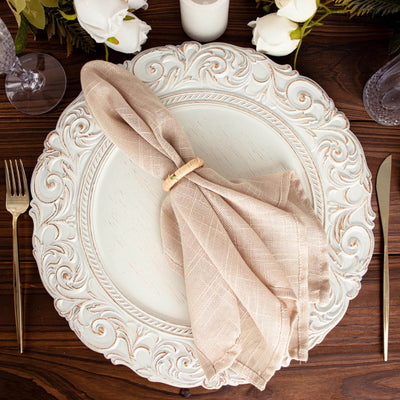 Elegant beige napkin on a decorative plate, styled for dining.