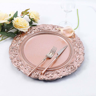 Rose gold decorative charger plate with fork and knife, styled with flowers.