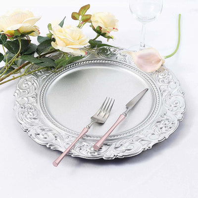 Elegant silver serving platter with pink-handled fork and knife, styled with roses.