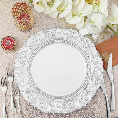 Ornate silver charger plate on a decorated table setting with floral accents.