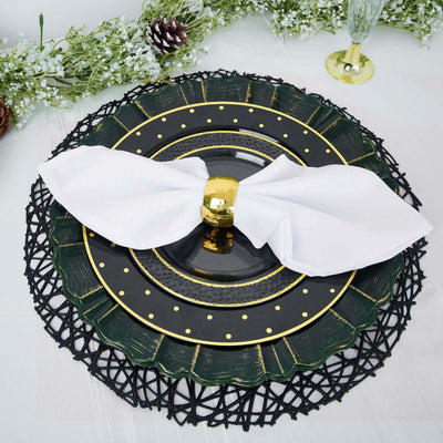 Elegant black and green dinner plate set with a white napkin and gold ring