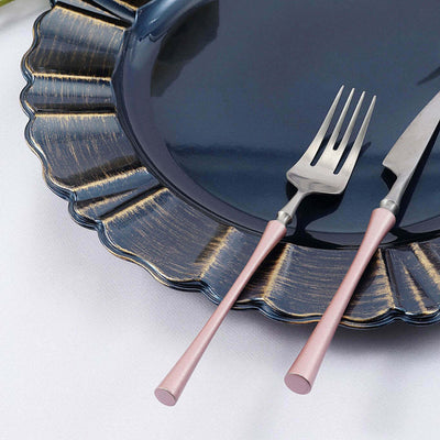 Elegant navy plate with gold accents and pink-handled knife and fork.