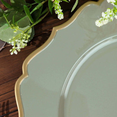 Elegant green plate with scalloped gold edge on wooden table.