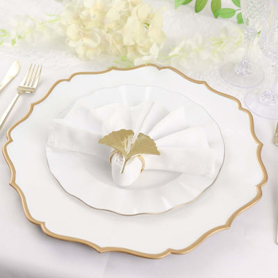 Elegant white dinner plate with gold trim and folded napkin decoration.
