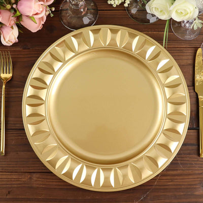 Gold decorative charger plate with elegant leaf design on wooden table setting.
