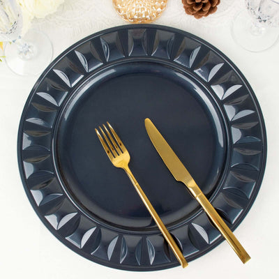 Navy blue dinner plate with gold fork and knife on a textured table setting.