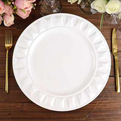 Elegant white decorative plate with a textured rim on a wooden table.