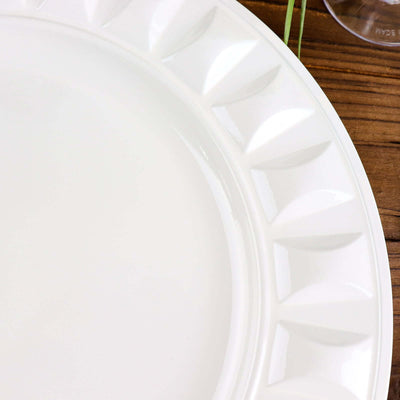 White decorative plate with textured rim on a wooden surface.