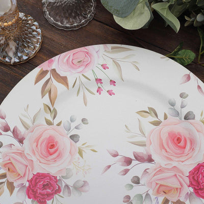 Floral design plate with pink roses and greenery on a rustic wooden table.