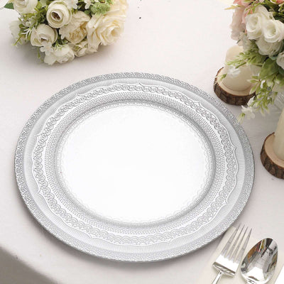 Elegant silver decorative plate on a table setting with flowers.