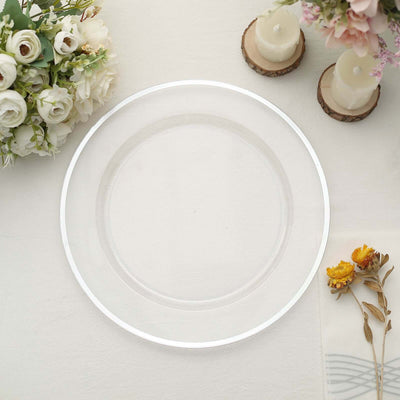 Clear decorative plate on a soft, neutral table setting with flowers and candles.