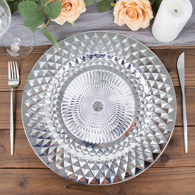 Decorative silver plate with geometric design, styled for dining table setting.