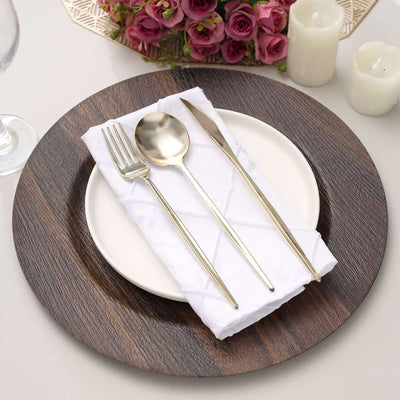 Elegant table setting with silverware and white napkin on a wooden charger plate.