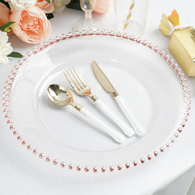 Elegant clear plate with pink beaded rim and gold cutlery set.