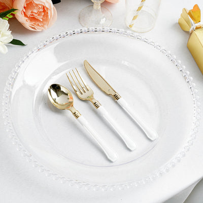 Elegant gold and white cutlery set on a clear plate