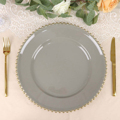 Elegant gray plate with gold beaded rim, styled with gold cutlery.