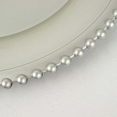 Decorative silver beaded trim on a round plate edge.