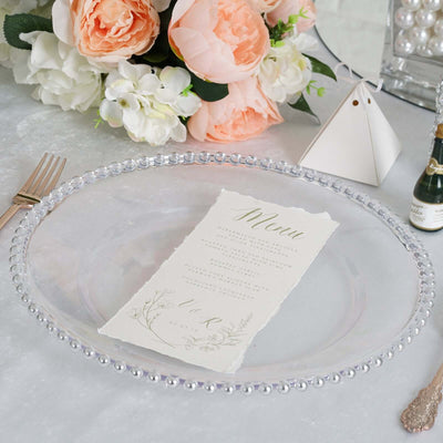 Elegant clear glass plate with menu card and floral arrangement